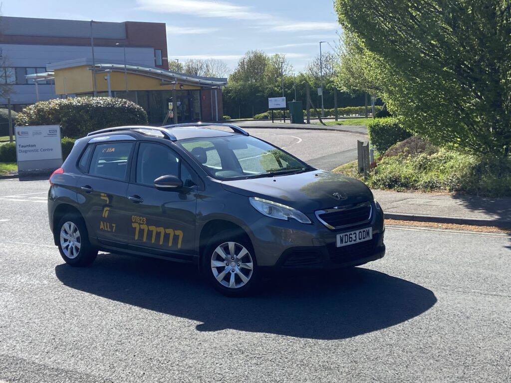 All 7 Taxis vehicle outside Taunton diagnostic centre providing local and hospital transport