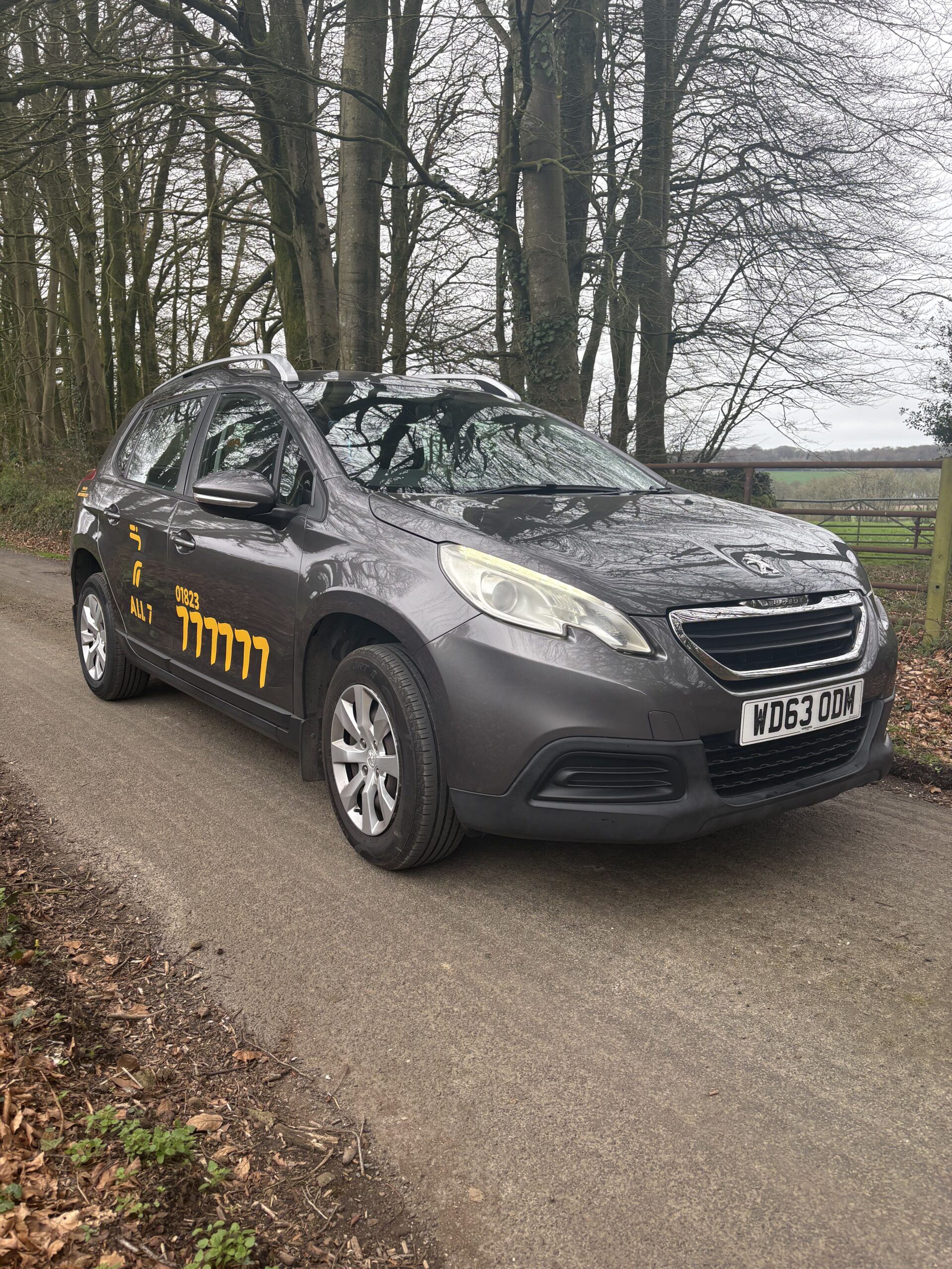 All 7 Taxis grey Peugeot taxi parked on a country road in Taunton Somerset