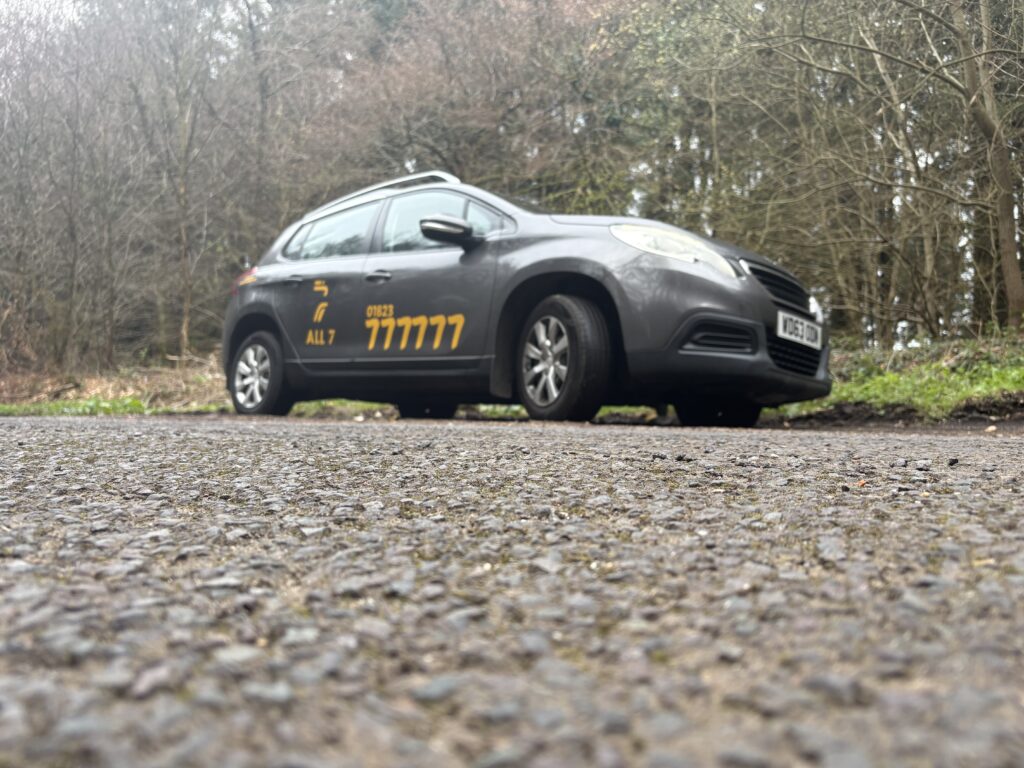 All 7 Taxis grey Peugeot taxi on a quiet country road in Taunton Somerset